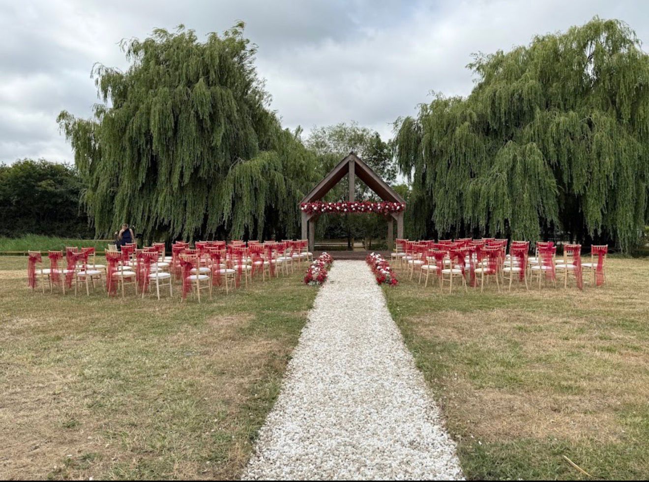 Outdoor ceremony lawn with aisle and timber arbor
